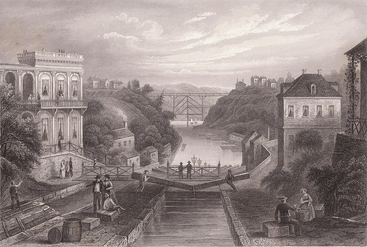 The locks at Lockport, New York, around 1855, with lock gates, a canal-side hotel and a bridge in the distance. Engraving published for Herrmann J. Meyer, public domain, via Wikimedia Commons